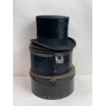 A back top hat, along with two black hat tins