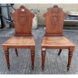A pair of Victorian mahogany hall chairs each stam