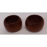 A pair of teak condiment pot holders