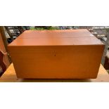 Orange painted wooden chest on wheels