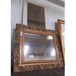 A heavily carved gilt framed mirror together with