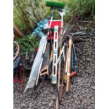 Various garden tools to include rakes, a pick axe,