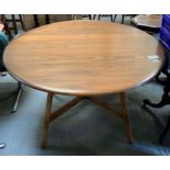 A mid 20th century Ercol round drop leaf dining ta