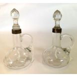 A pair of glass oil bottles with silver rim collar