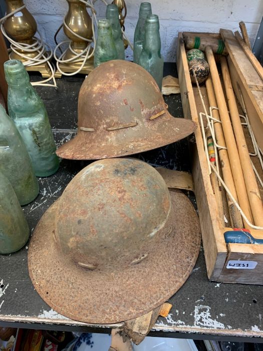 2 military helmets, possibly French, along with a