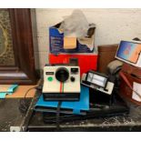 Shelf of camera equipment, polaroid, Toshiba lapto