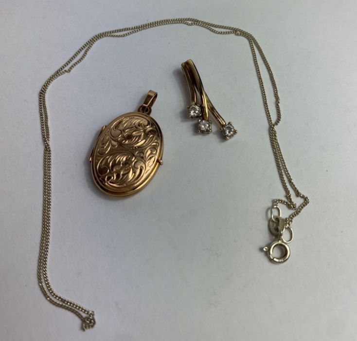 A 9 carat gold oval locket pendant; with a 9 carat