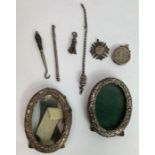 A pair of small oval silver photograph frames; wit