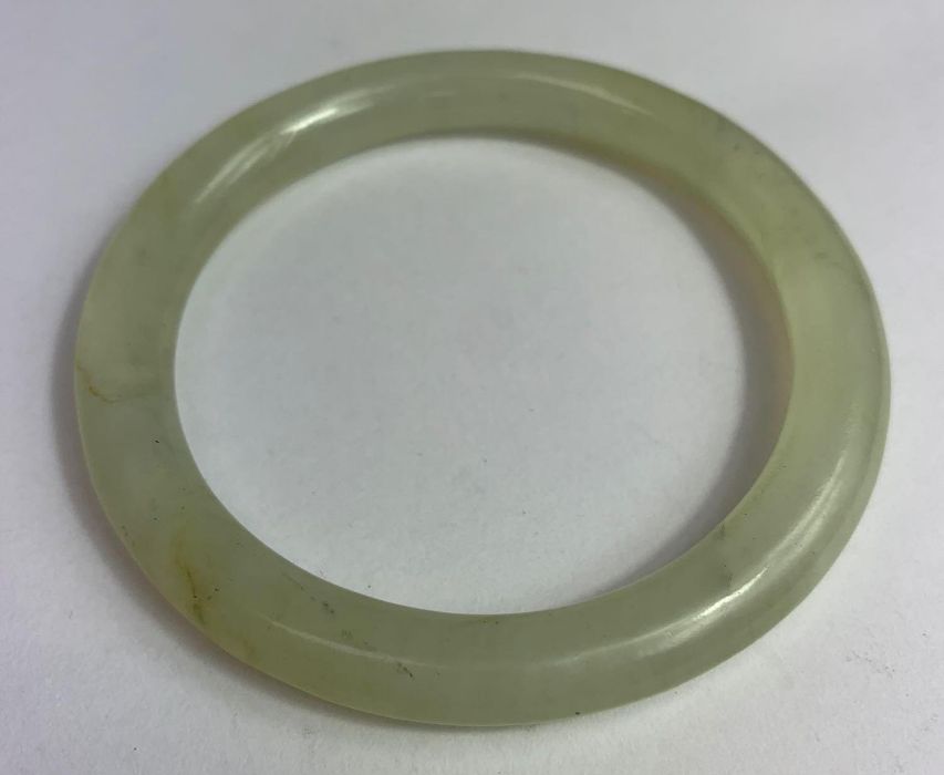 A plain jade bangle, of round section, inner diame