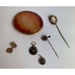 A shell cameo stickpin; another stickpin; an agate