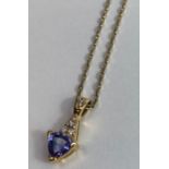 An 18 carat gold tanzanite and diamond pendant, th