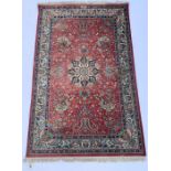 A Persian silk and wool rug, profusely decorated throughout