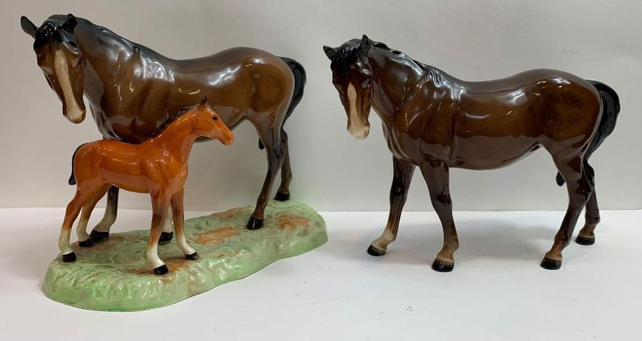 A Beswick group of a mare and foal standing on gra