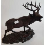 A bronzed metal figure of a red deer stag, the bas