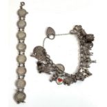 A silver bracelet with charms attached; and a brac