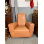A modern tan leather open armchair