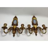 A pair of gilt metal wall lights, each with a Wedg