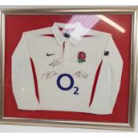 A framed England rugby shirt signed by Martin John