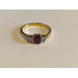 A three stone ring, with central oval ruby flanked