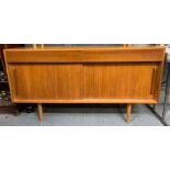 A mid century teak sideboard with sliding doors, t