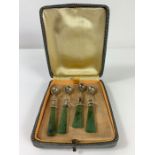 A cased set of four salt spoons, with green hardst