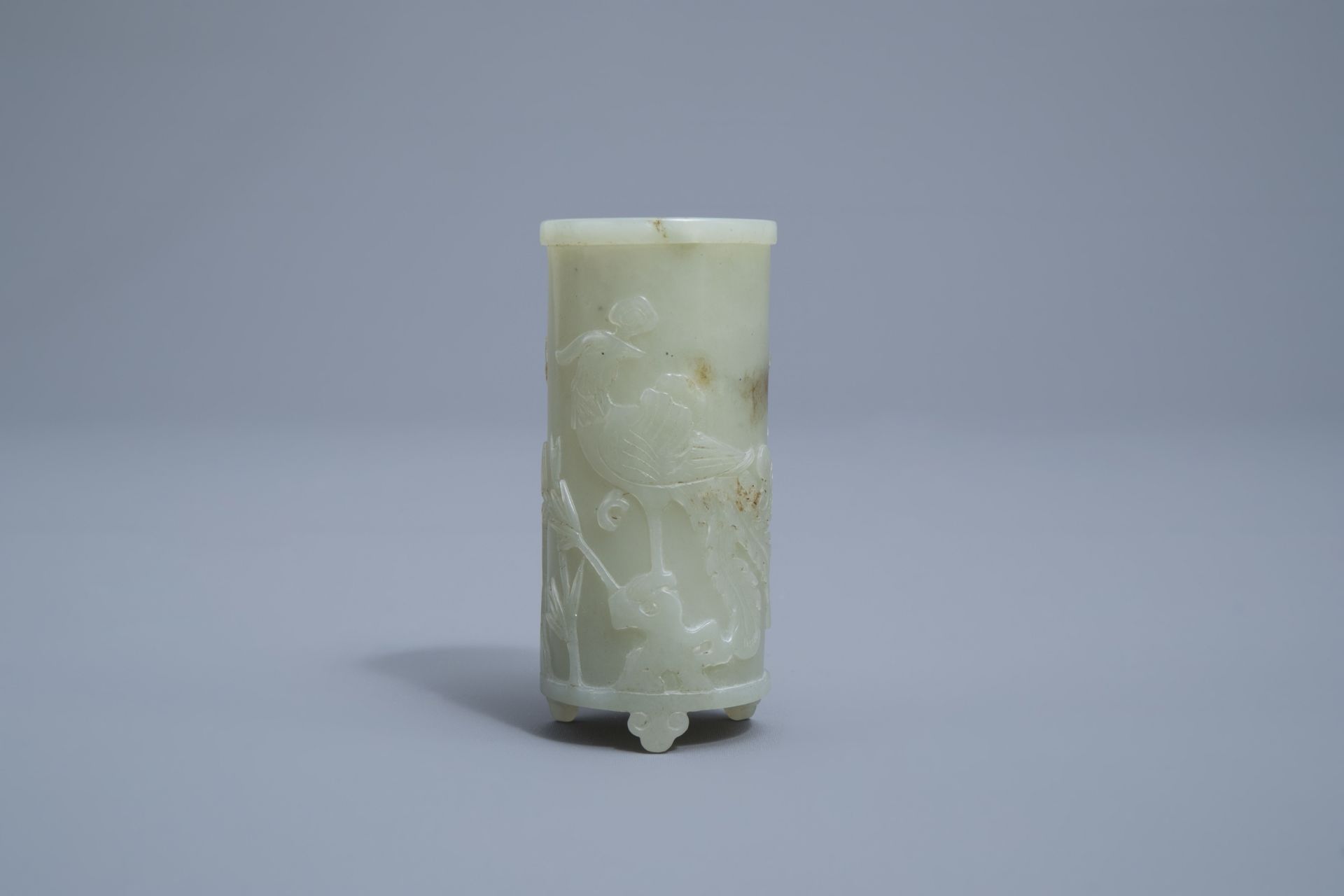 A Chinese celadon jade tripod brush pot with a phoenix among blossoming branches, 19th C.