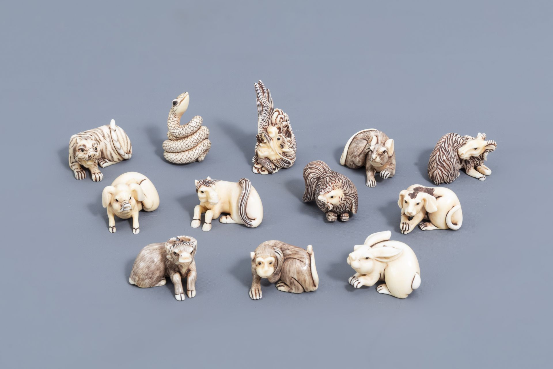 Twelve Japanese animal shaped netsuke in their display cabinet, first half of the 20th C. - Image 2 of 27