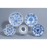 Four Dutch Delft blue and white chargers and a polychrome plate with floral design, 18th C.