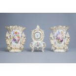 A French mantel clock and a pair of vases in gilt and polychrome old Paris porcelain, 19th C.