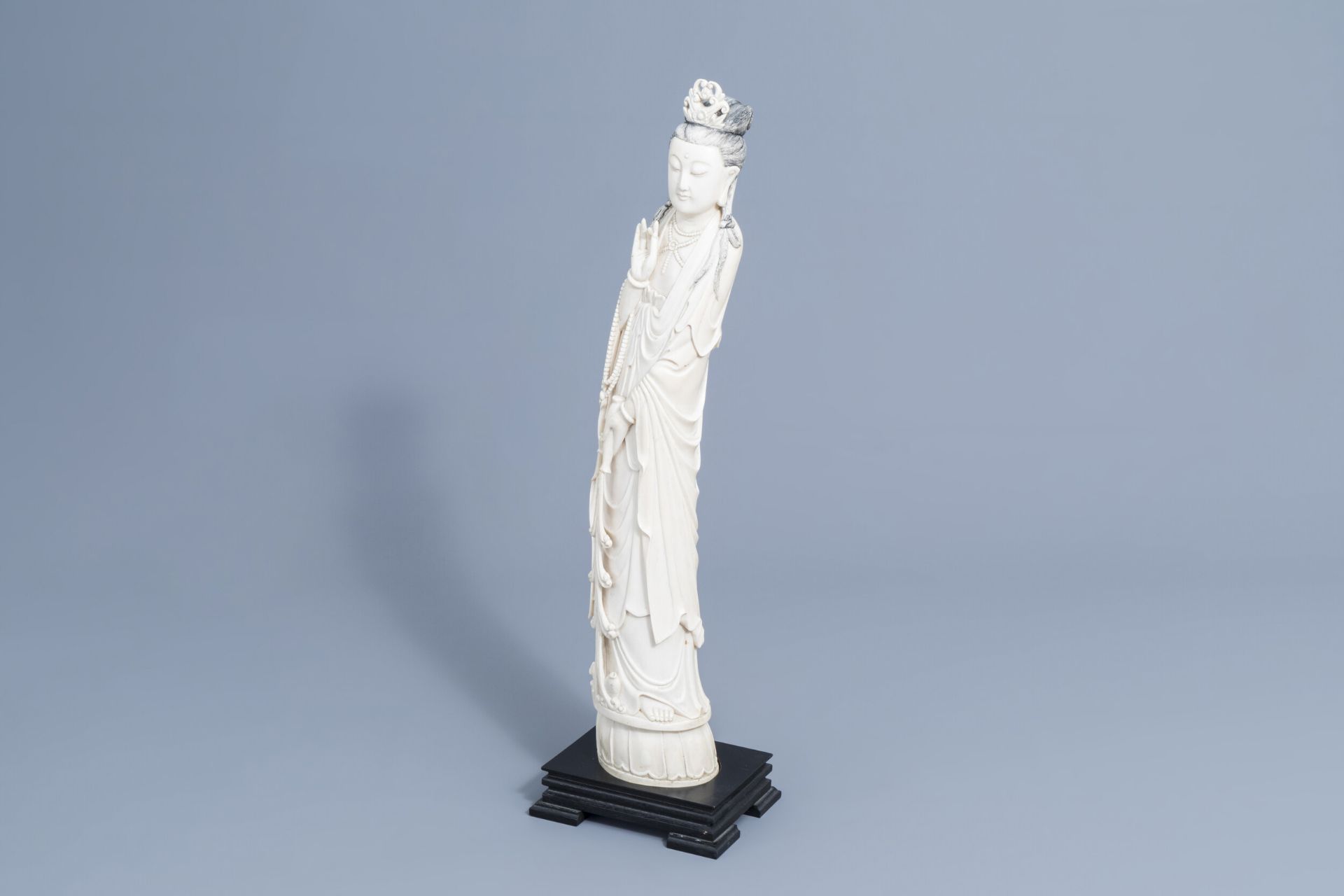 A large Chinese carved ivory figure of a lady on a wooden base, first half of the 20th C.