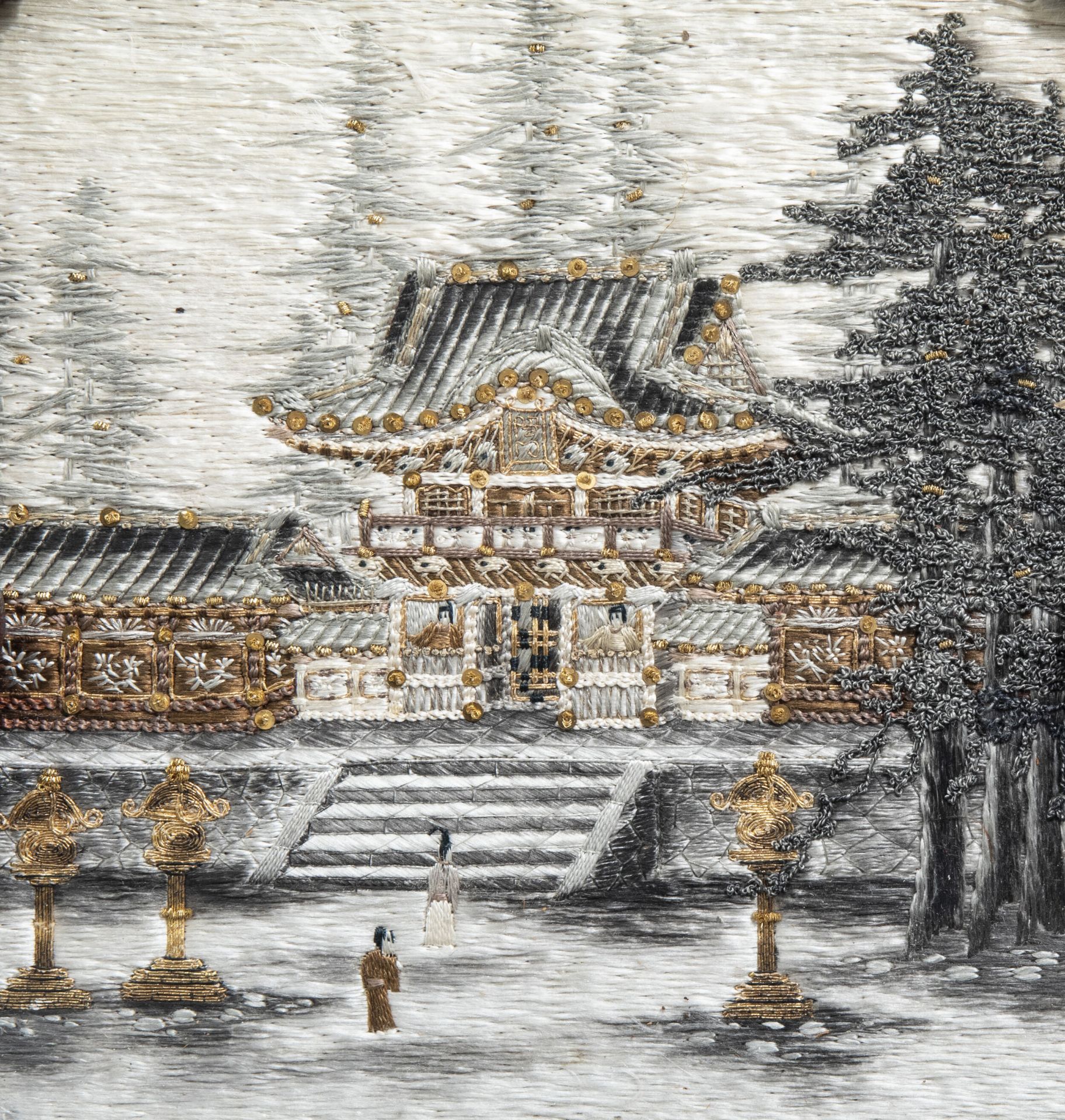 A Japanese silk embroidery with a temple in a lacquered and carved wooden frame, Meiji, 19th C.