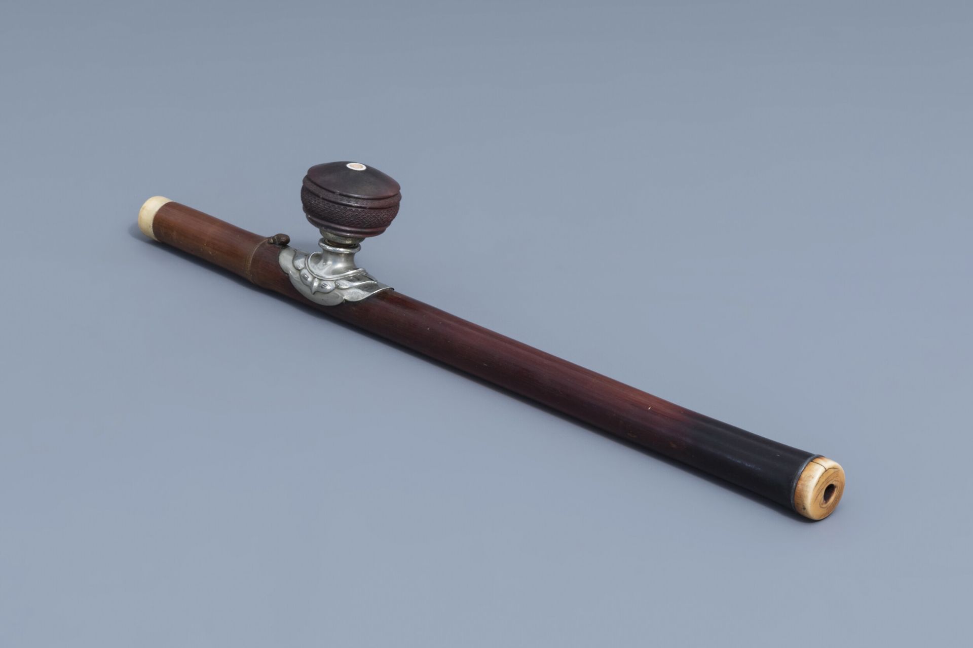 A Chinese bamboo opium pipe, an ivory mouth- and endpiece and a stoneware damper, 19th C.