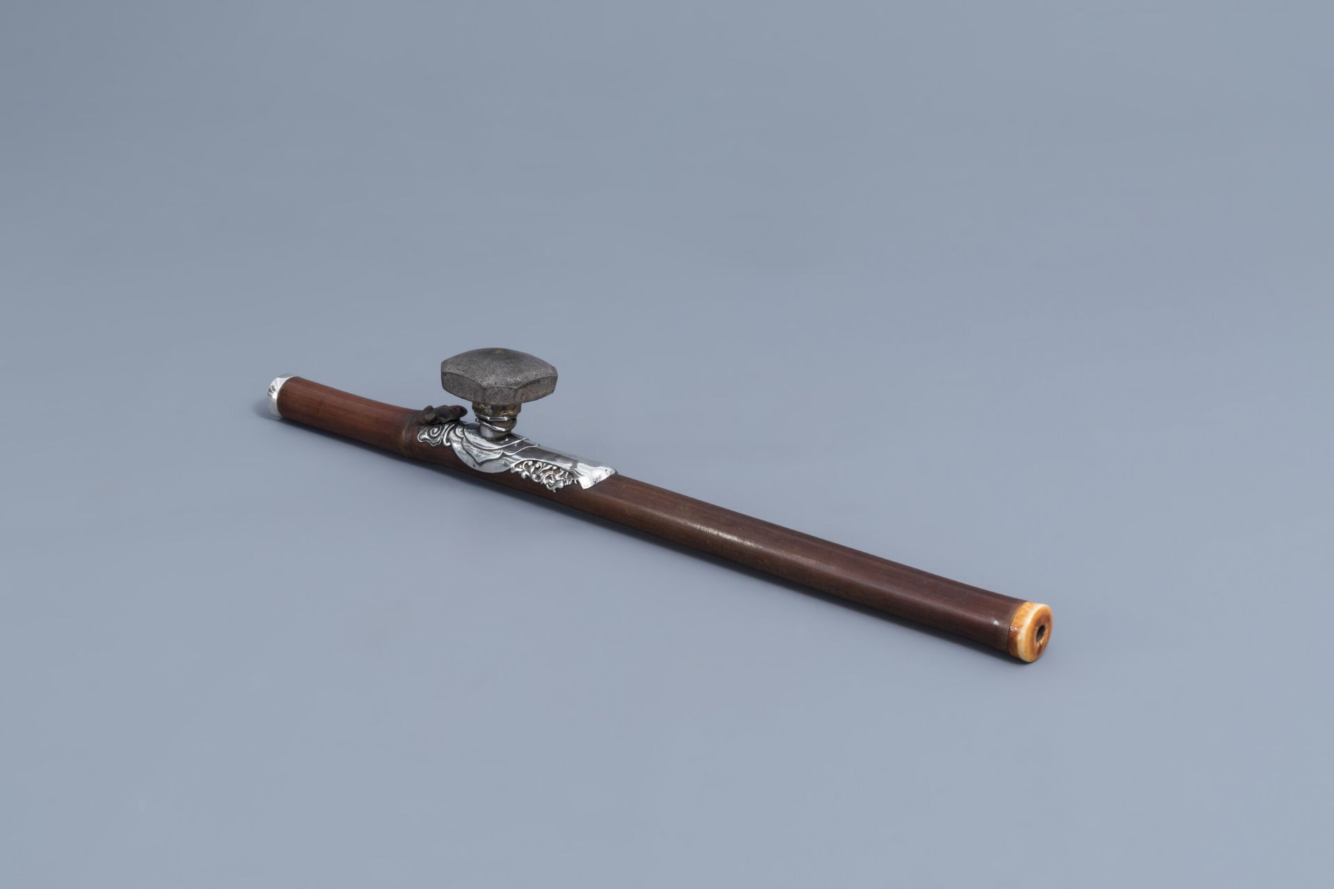 A Chinese bamboo opium pipe with silver saddle, ivory mouthpiece and stoneware damper, 19th C.