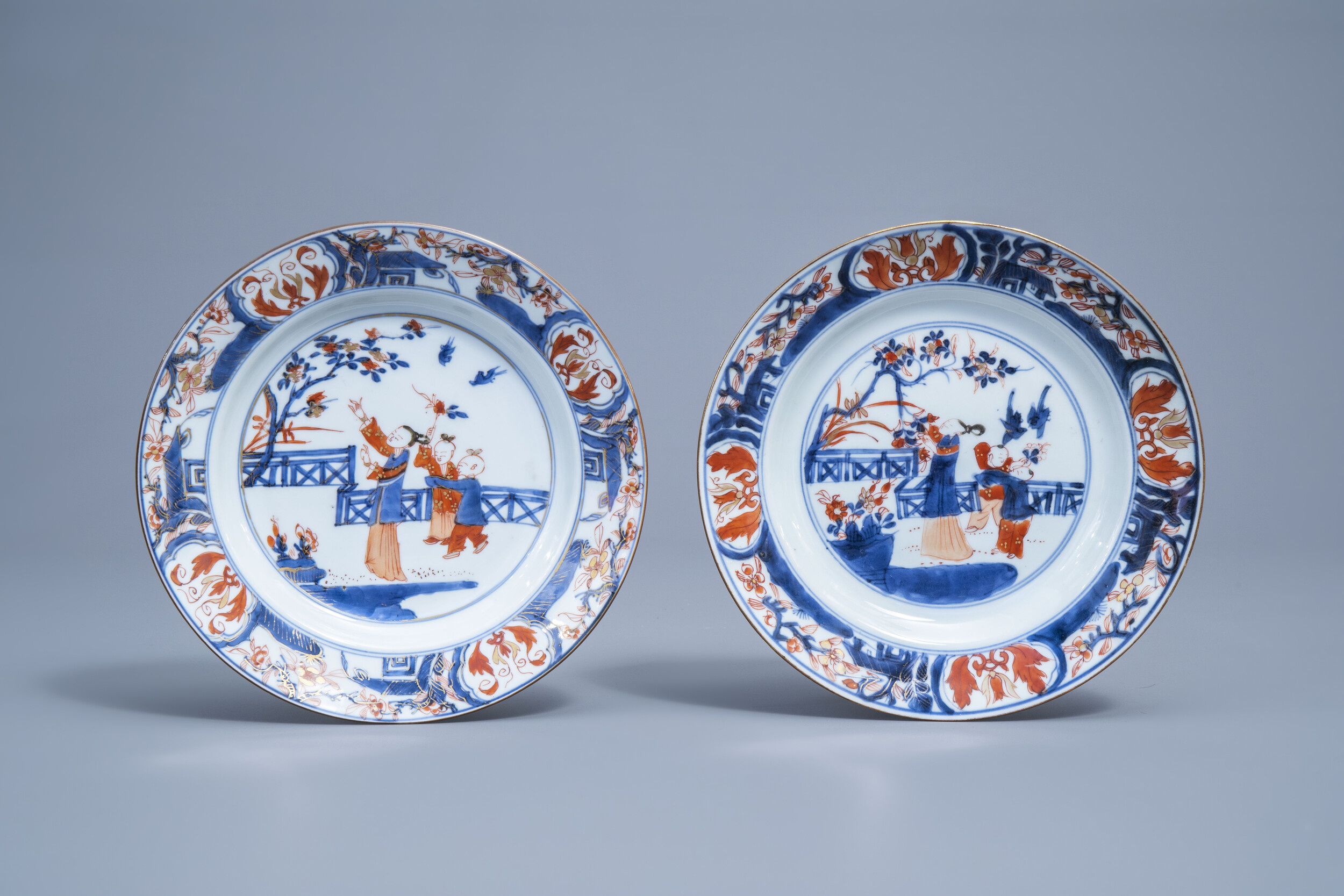 A pair of Chinese Imari style plates with figures in a garden, Kangxi