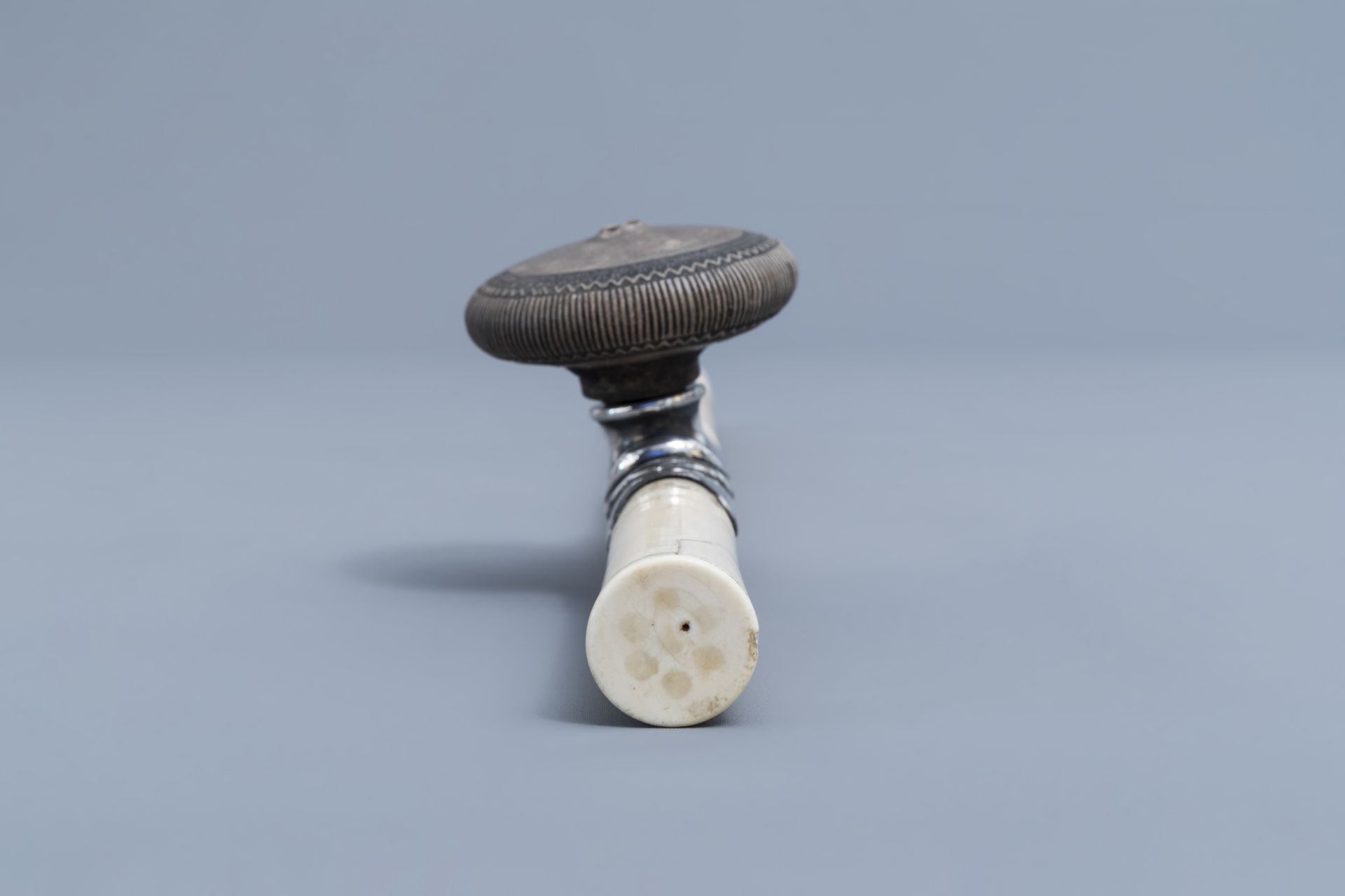 A Chinese ivory opium pipe finished with a silver saddle and a stoneware damper, 19th C. - Image 7 of 9