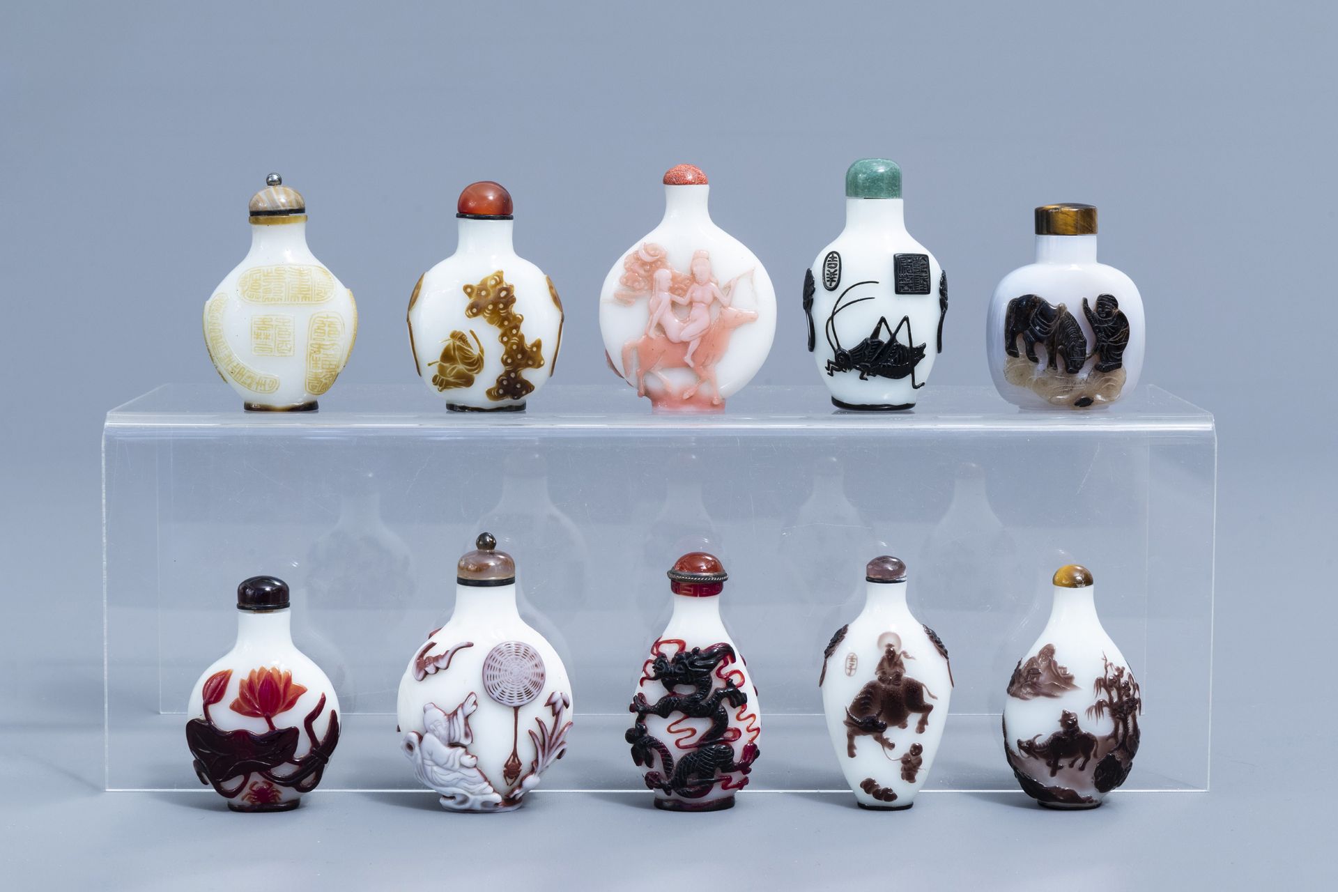 Nine Chinese overlay glass snuff bottles and one in agate, 20th C.