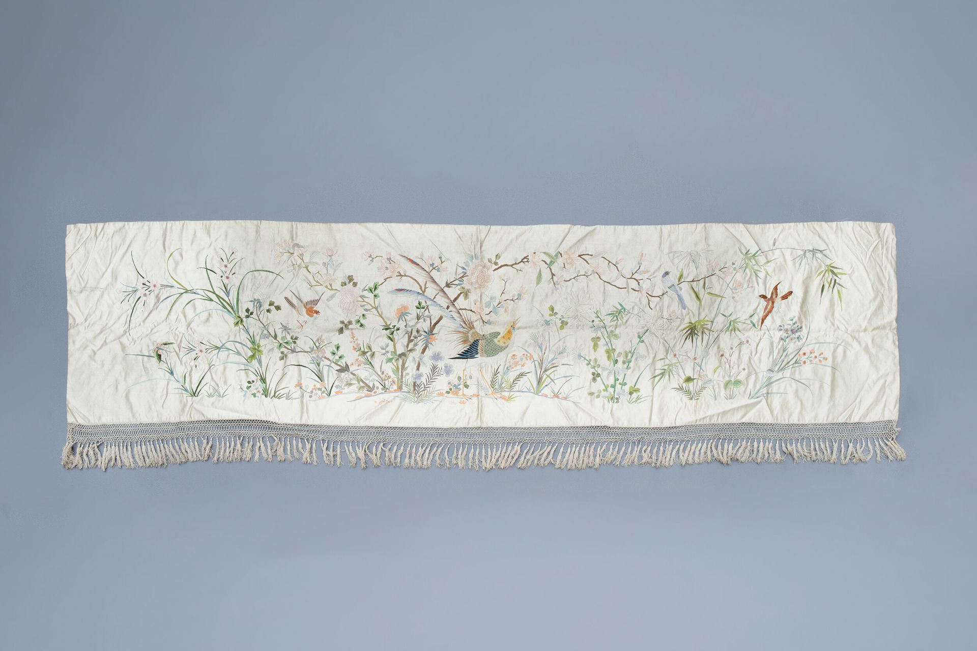 A Chinese horizontal silk embroidery with birds and a butterfly among flower branches, 19th C.