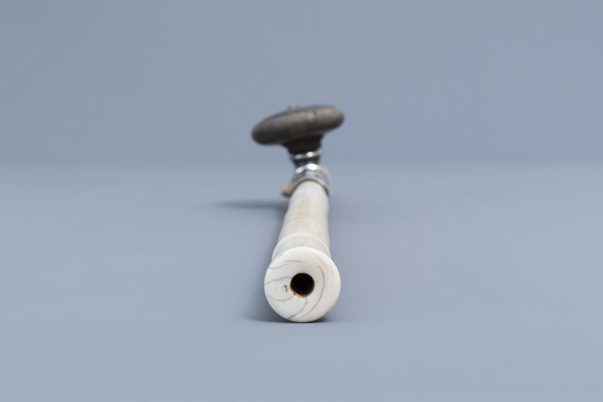 A Chinese ivory opium pipe finished with a silver saddle and a stoneware damper, 19th C. - Image 6 of 9