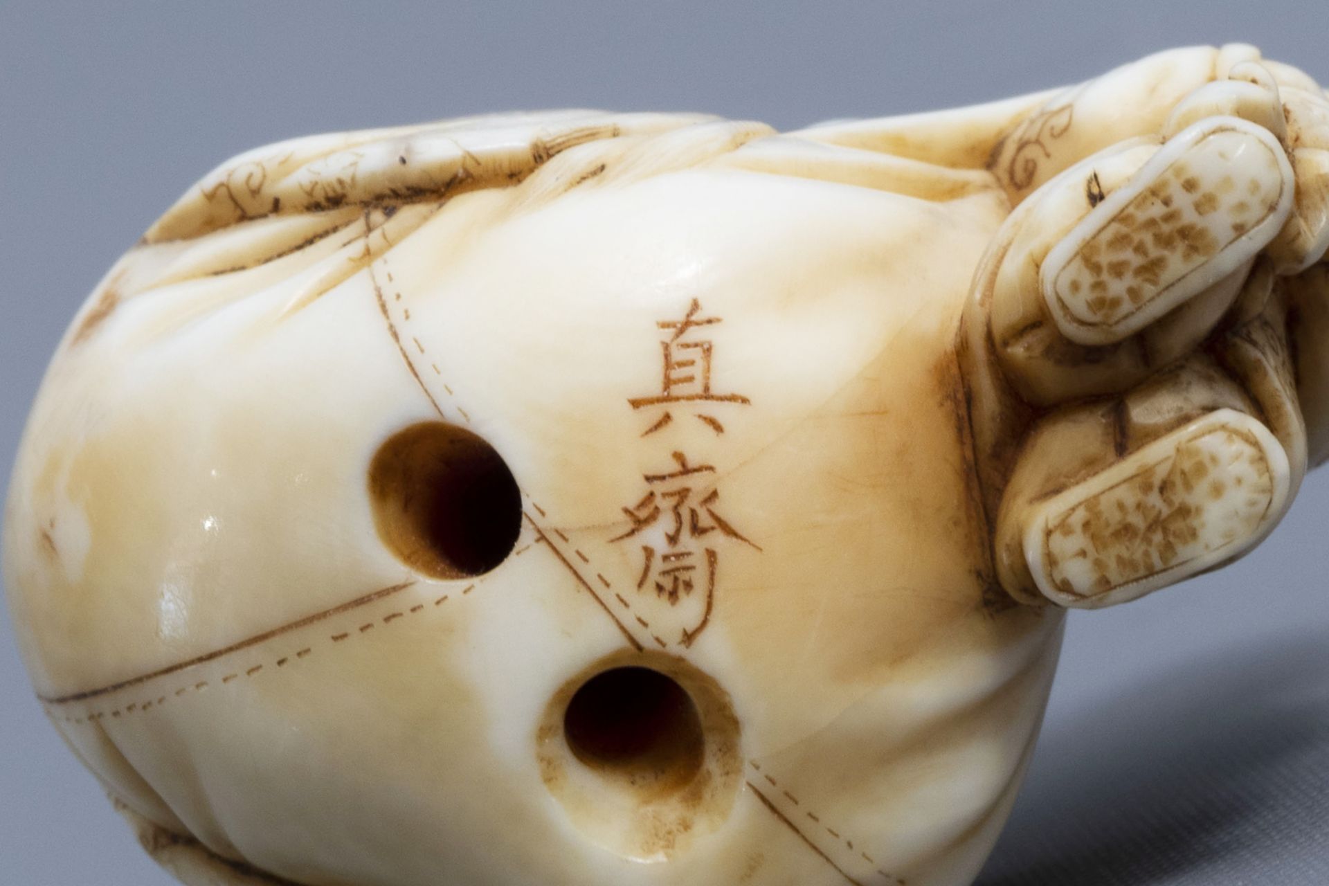 A Japanese ivory netsuke of a laughing Buddha with his servant, signed Shinsai, Edo - Image 9 of 9