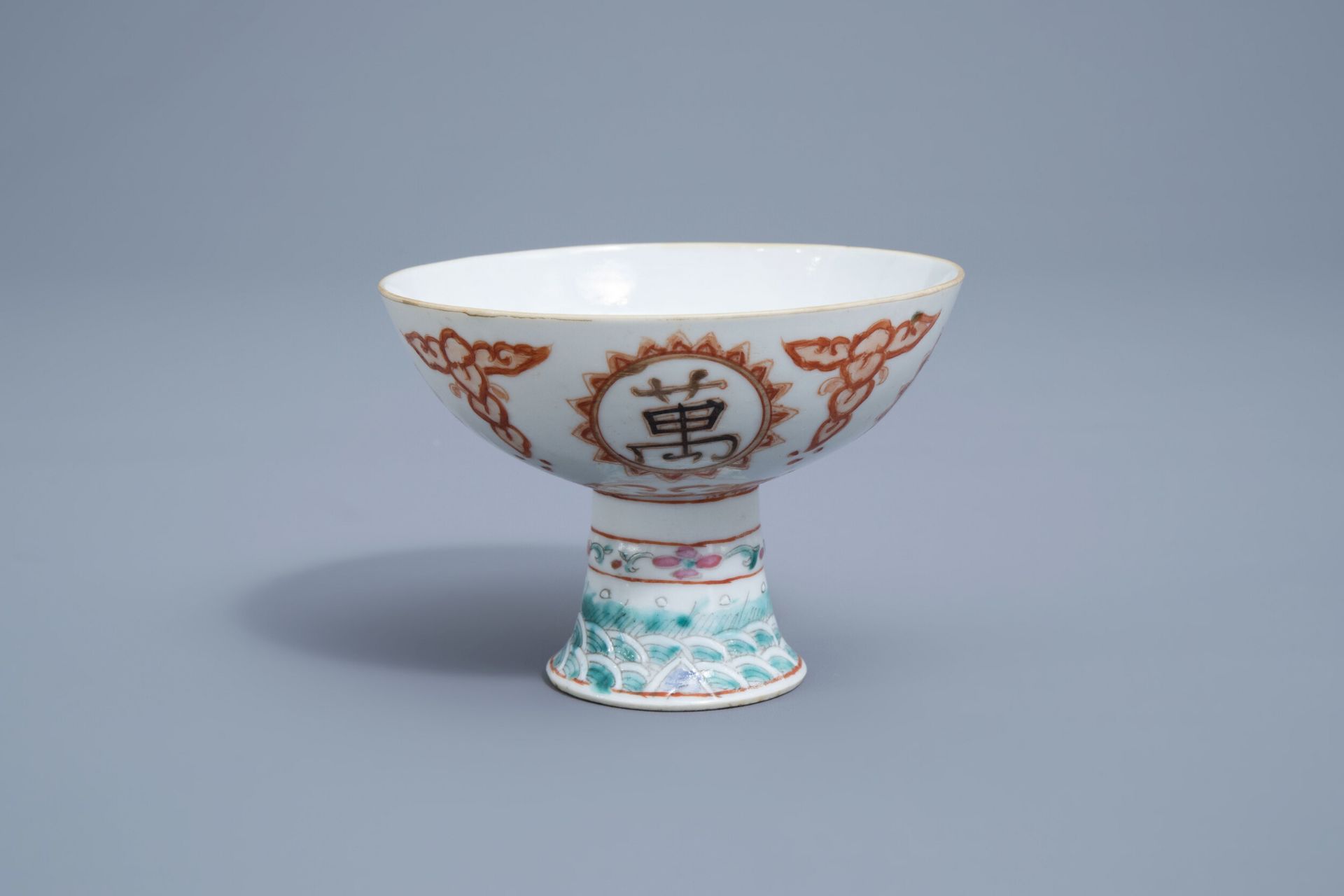 A Chinese famille rose, iron red and gilt stem cup, 19th C.