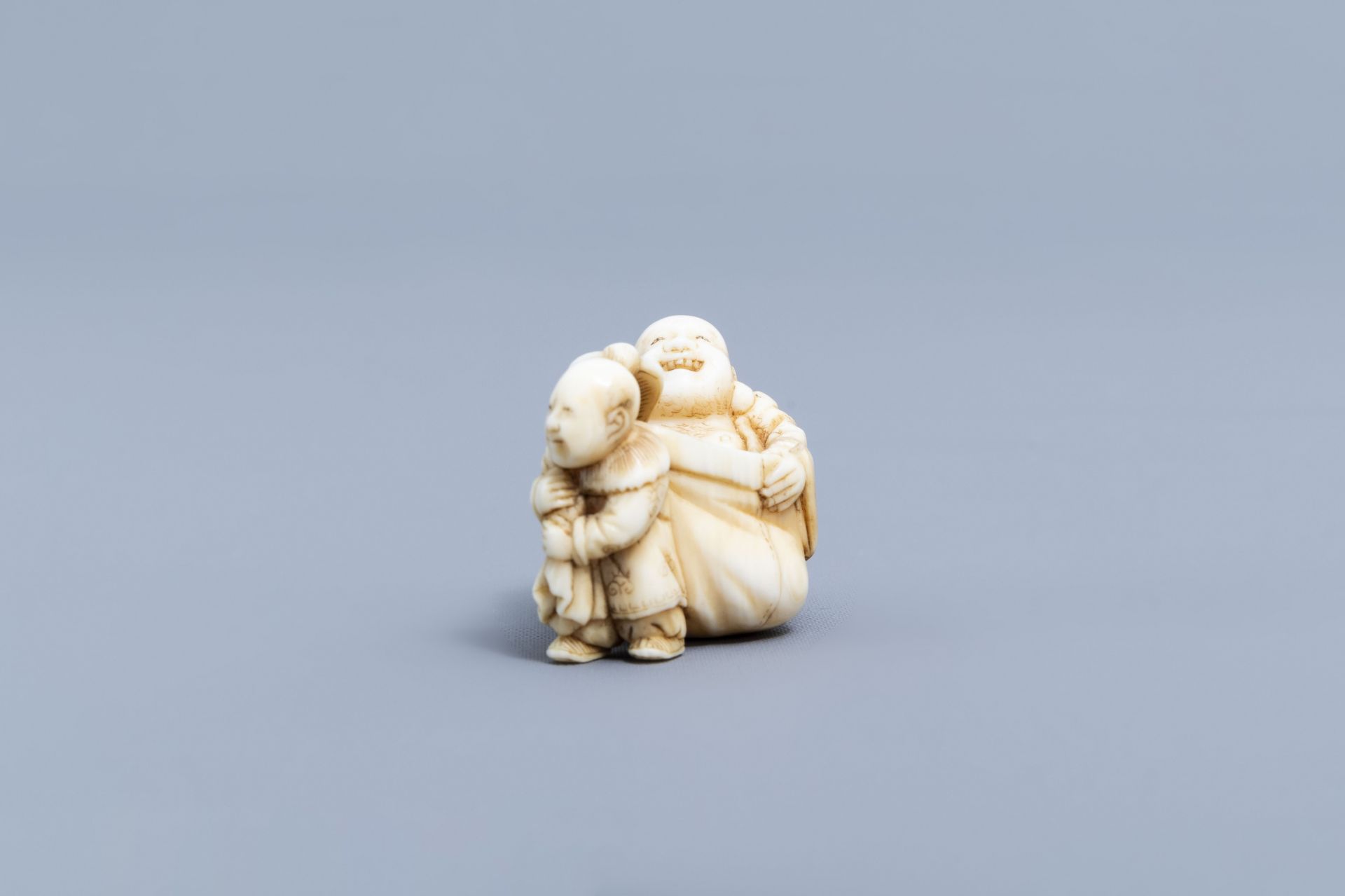 A Japanese ivory netsuke of a laughing Buddha with his servant, signed Shinsai, Edo - Image 6 of 9