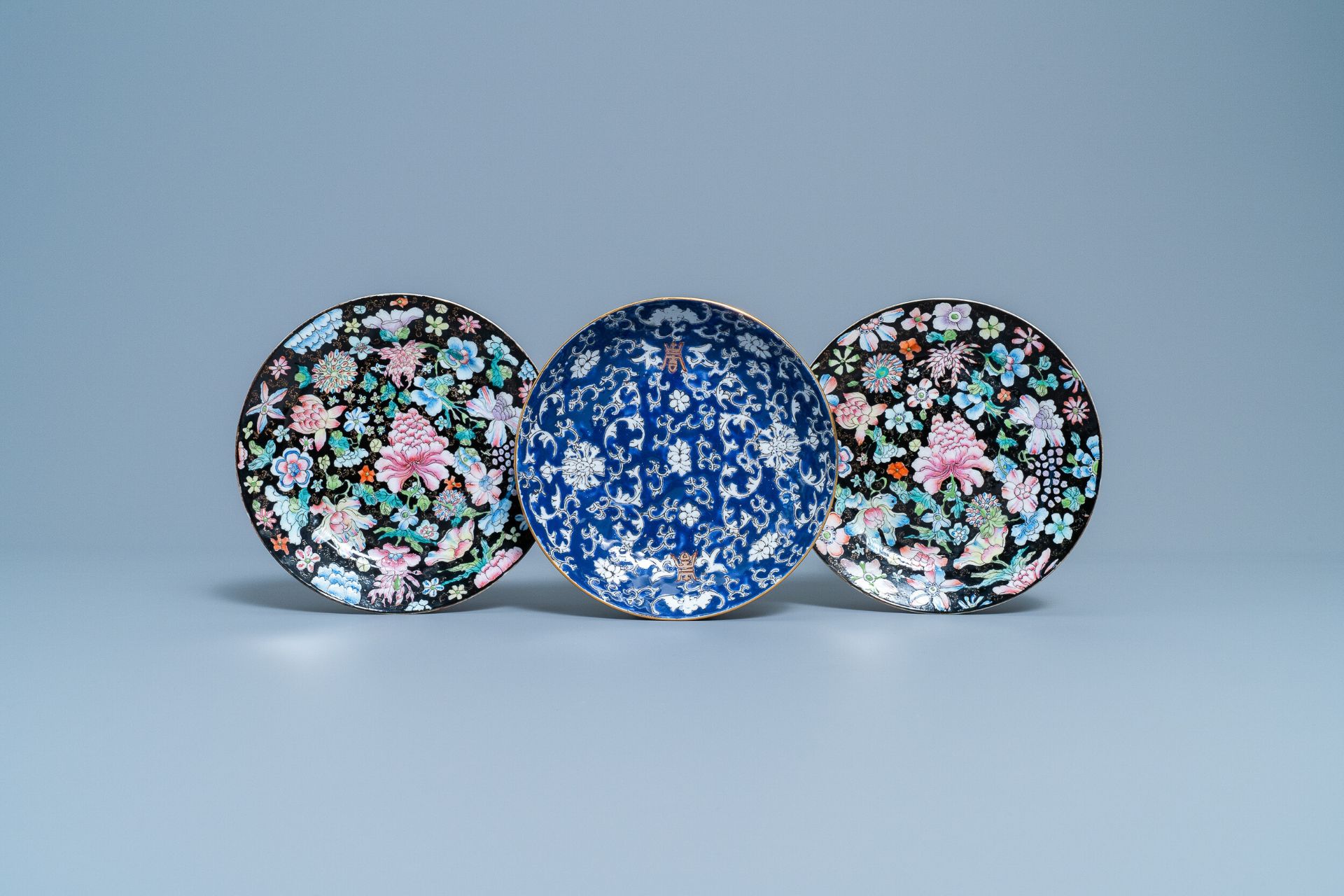 A pair of Chinese famille rose 'millefleurs' plates and a blue ground plate, 19th/20th C.