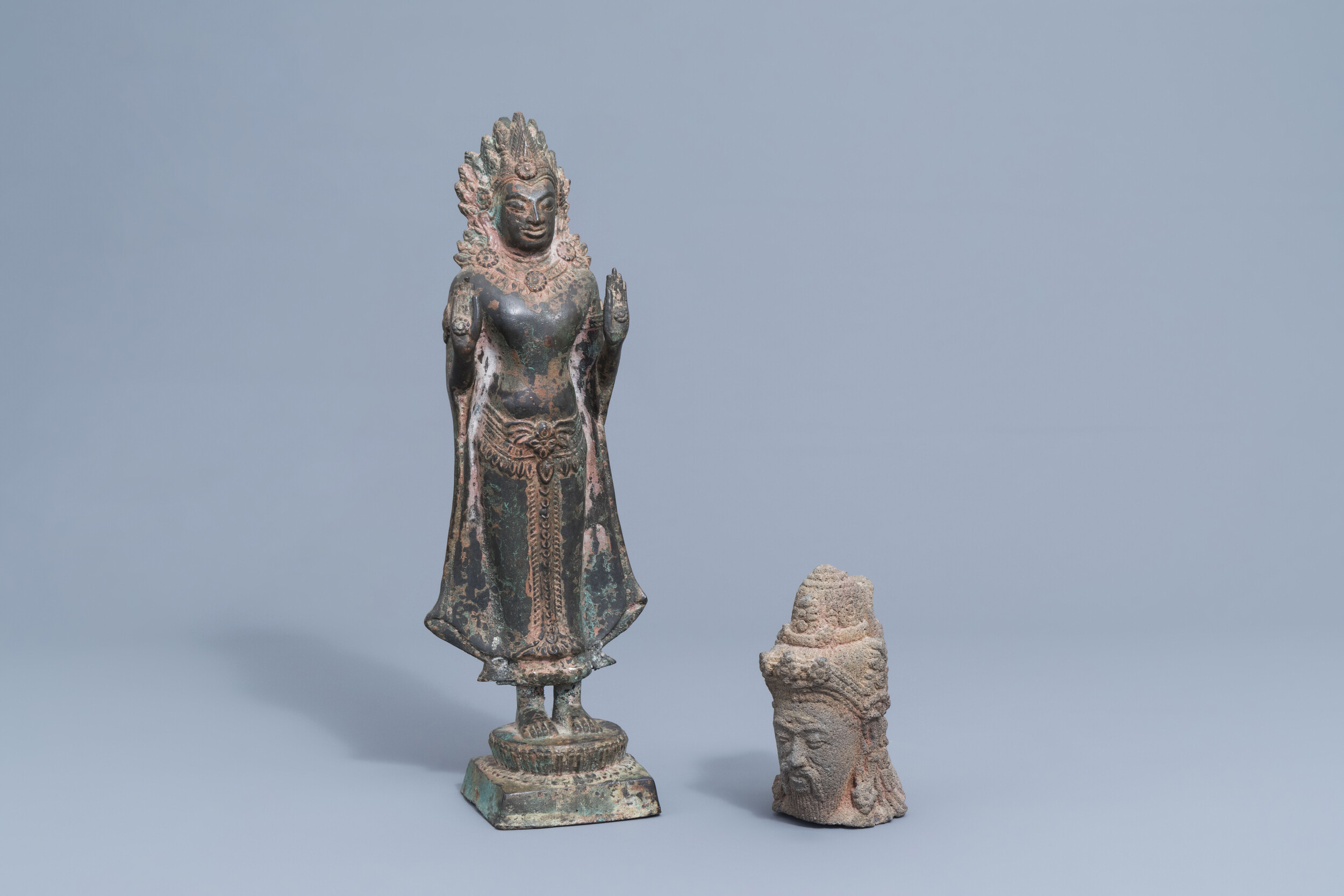 A lava stone scholar's head and a bronze figure of a Buddha, Southeast Asia, 19th/20th C.