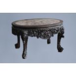 An oval Chinese finely carved wooden table with marble top, 19th C.