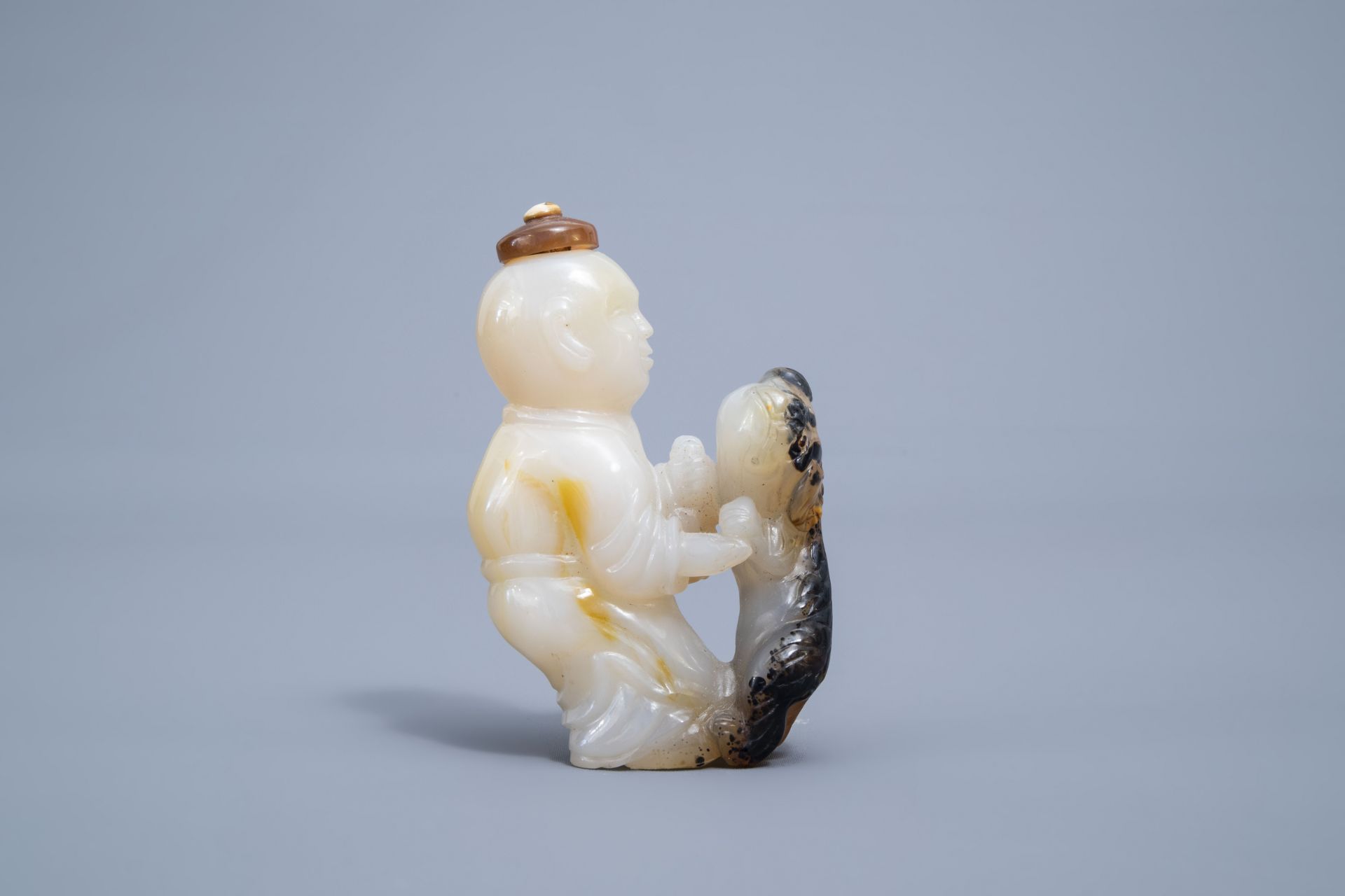 A Chinese shadow agate 'boy and dog'-shaped snuff bottle, 19th/20th C.