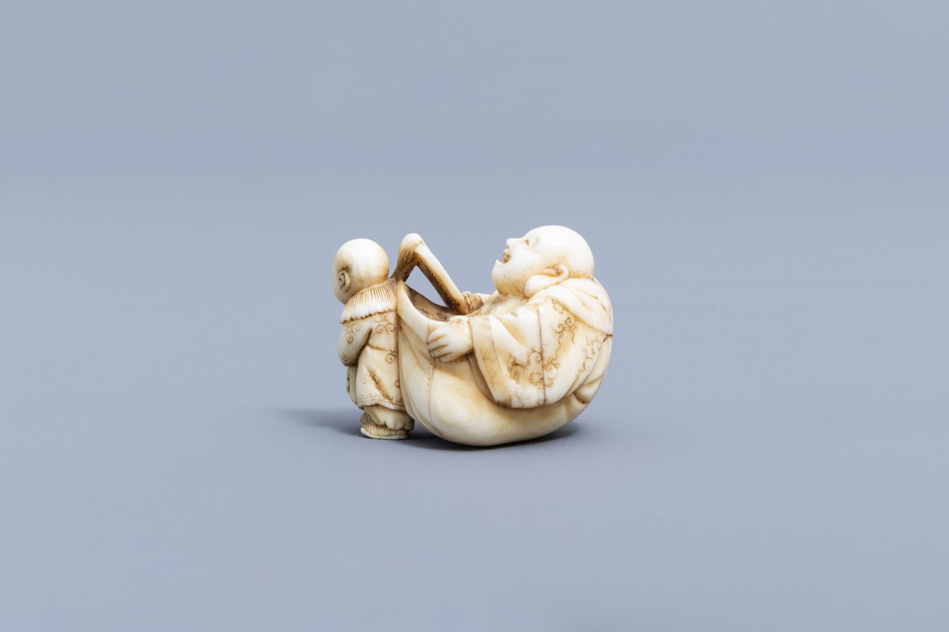 A Japanese ivory netsuke of a laughing Buddha with his servant, signed Shinsai, Edo - Image 5 of 9