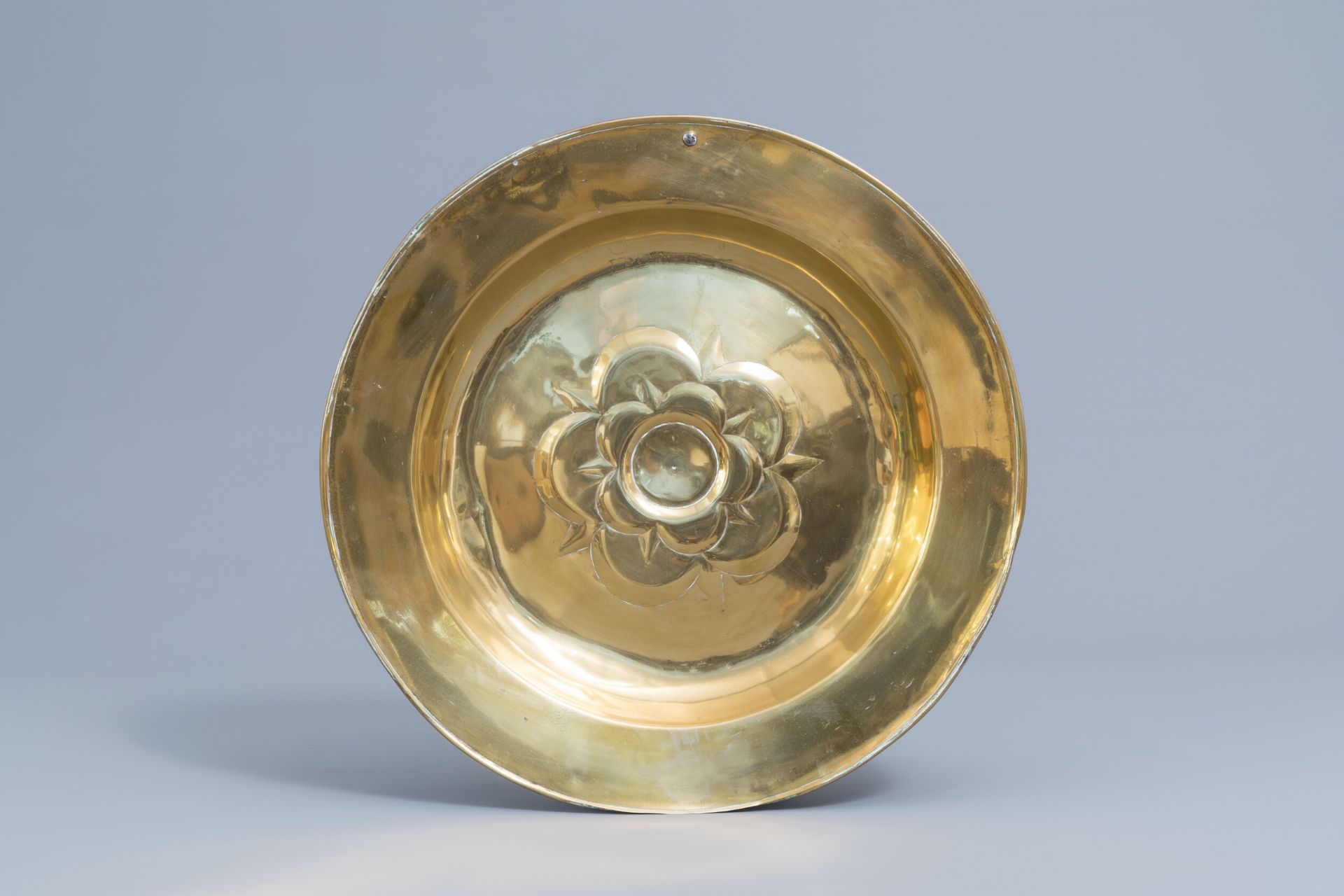 A large German brass alms dish with floral design, possibly 17th C.