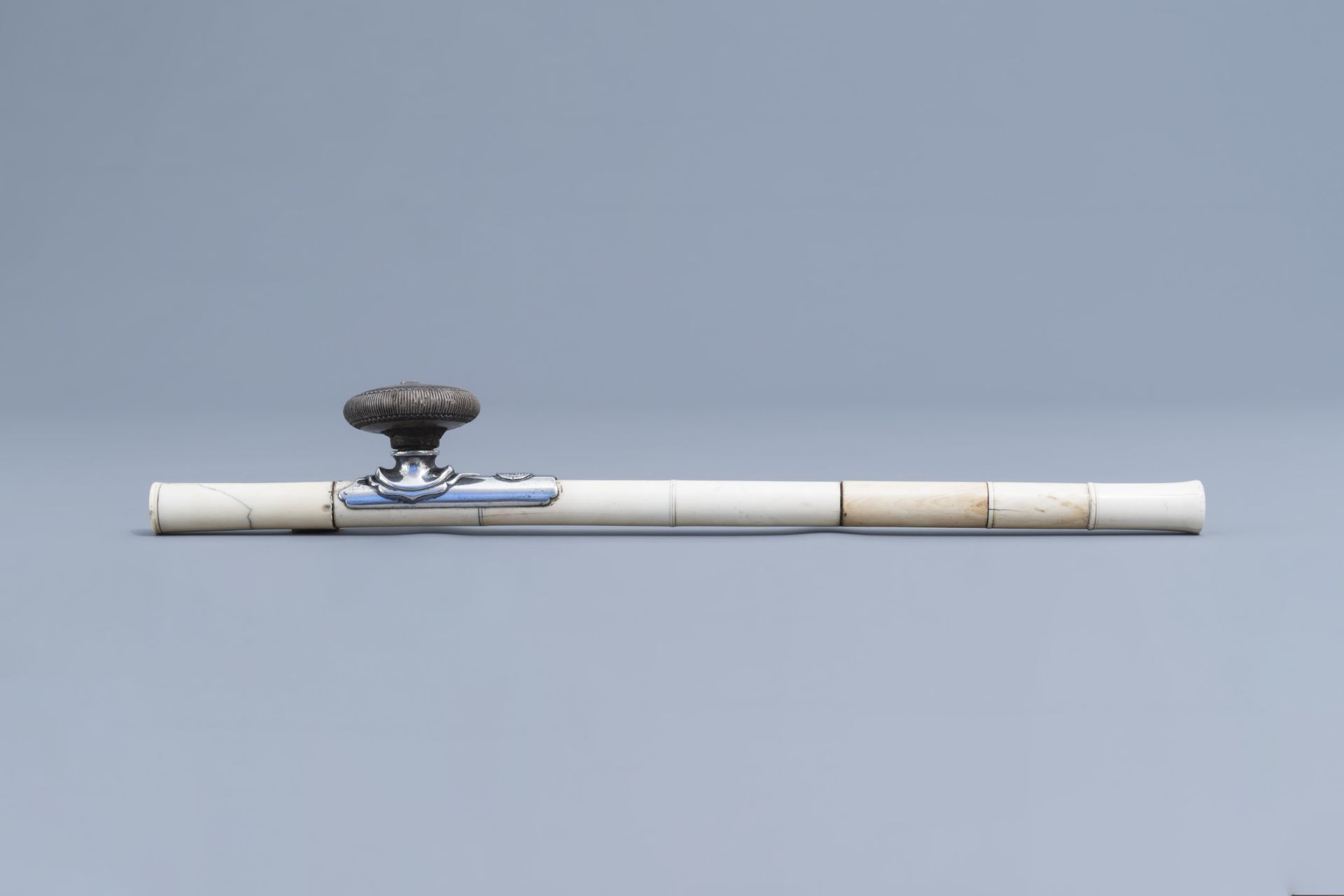 A Chinese ivory opium pipe finished with a silver saddle and a stoneware damper, 19th C. - Image 2 of 9