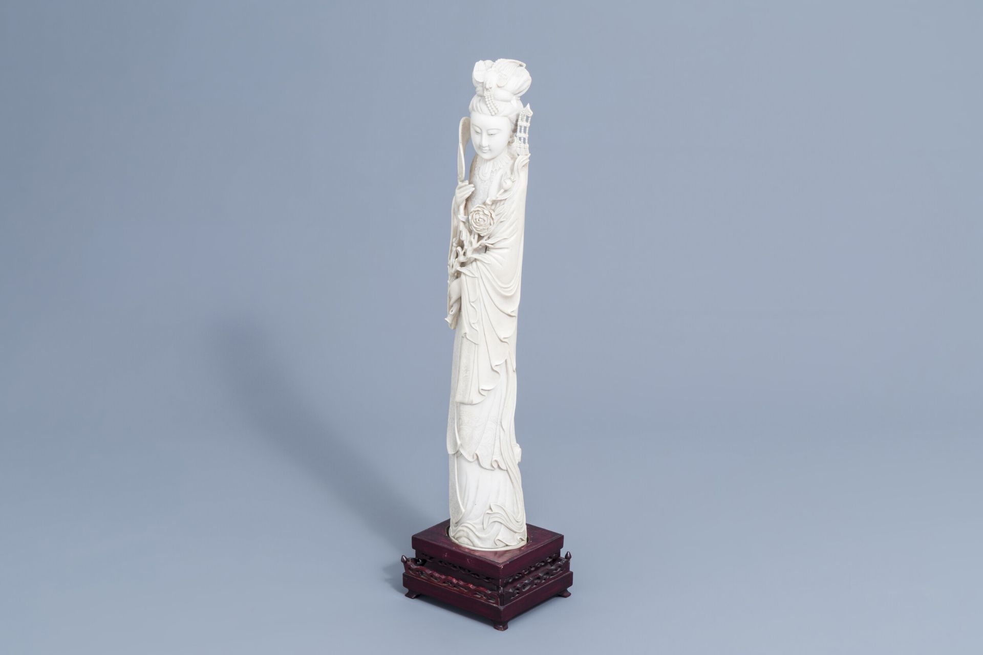 A large Chinese carved ivory figure of a lady on a wooden base, first half of the 20th C.