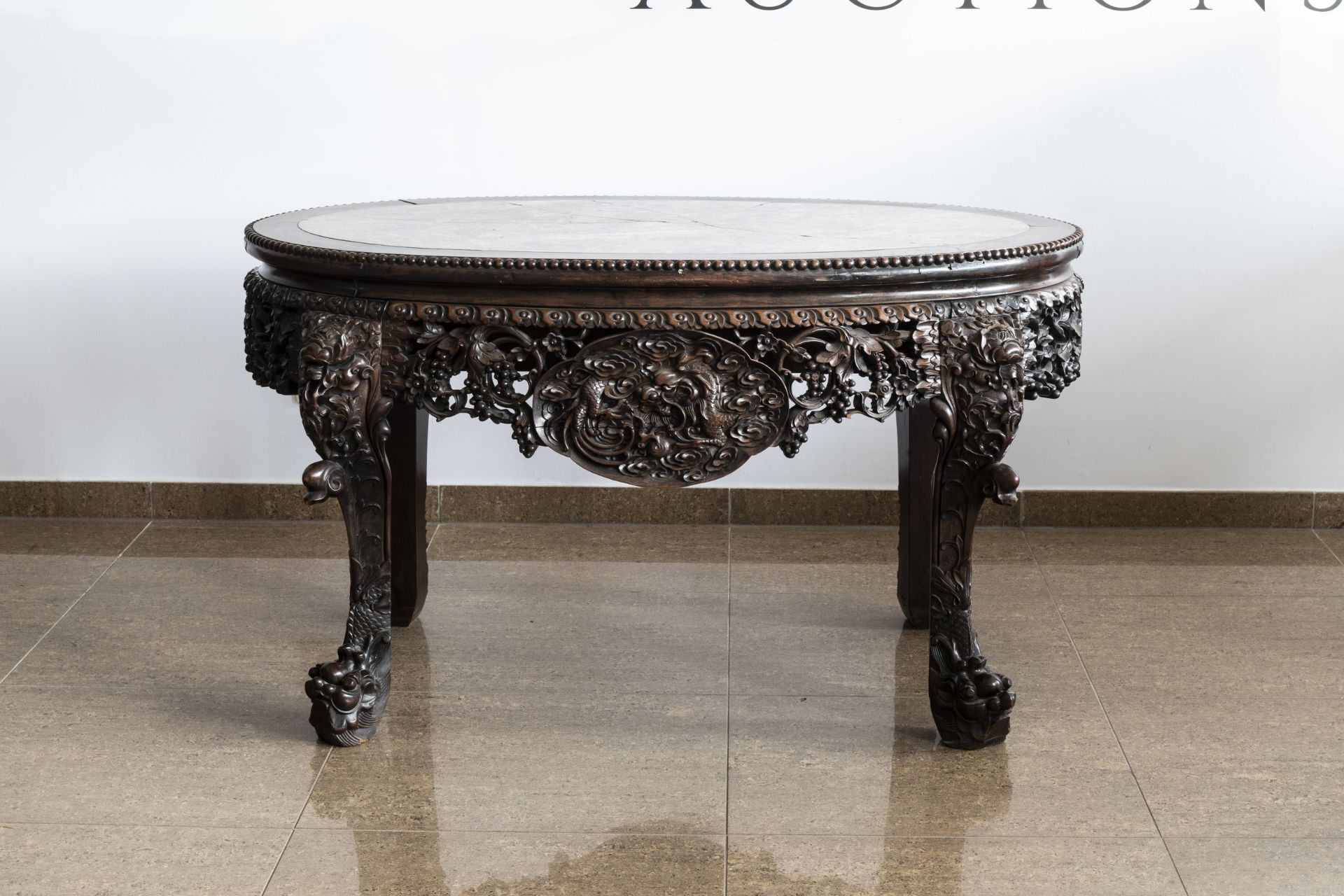 An oval Chinese finely carved wooden table with marble top, 19th C. - Image 4 of 6